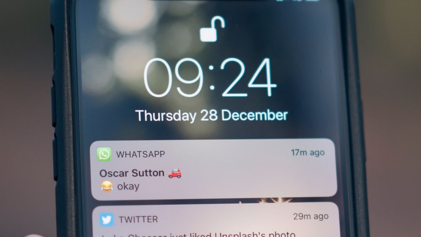 A phone screen is showing an incoming text with a laughing emoji