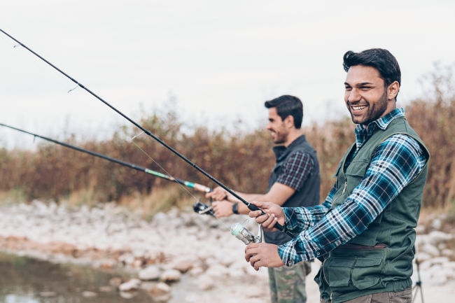 Two male friends fishing, a shoulder-to-shoulder activity to strengthen their friendship.