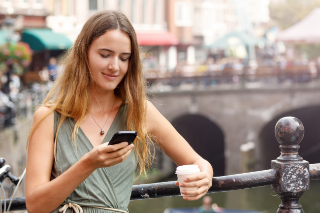 Person smiling while looking at her cellphone. 