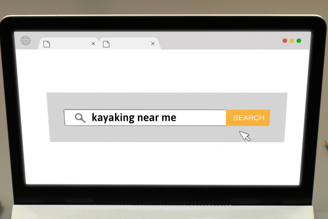 A computer screen shows a search page with the term "kayaking near me."