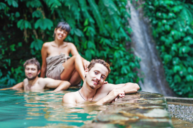 Three friends soak in a natural hot spring.
