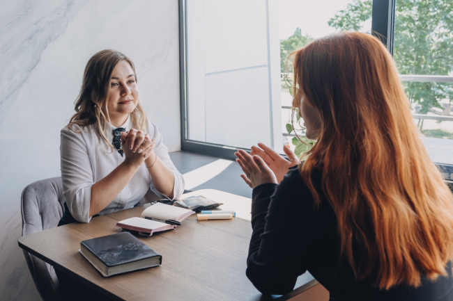 A person talks to a therapist, who listens attentively to them. 